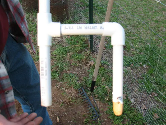 The wooden plug attached to the 6" long PVC pipe, that serves as the guage. 
