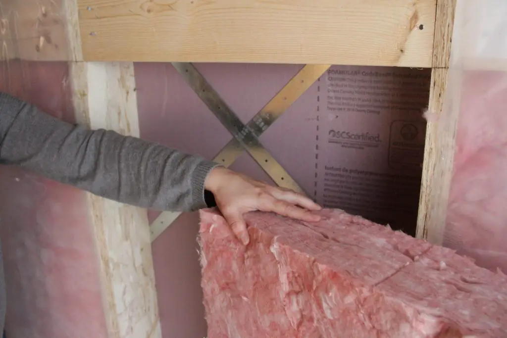 An image of a homeowner choosing an insulation material based on its R-value.