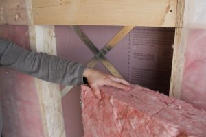 An image of a homeowner choosing an insulation material based on its R-value.