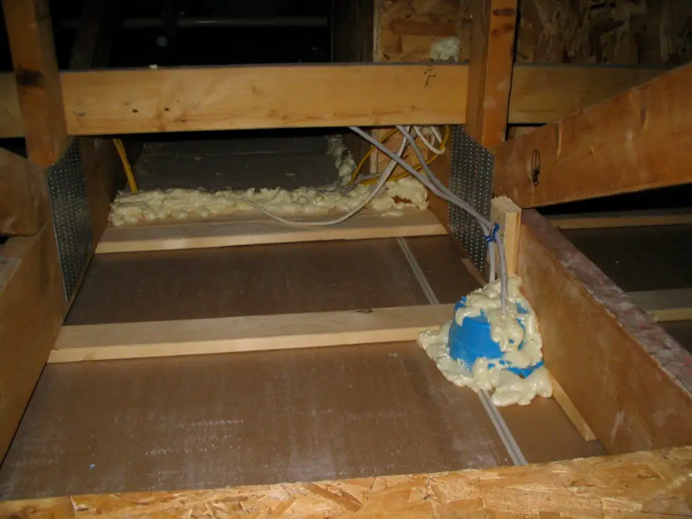 an image of an attic in the process of sealing home air leak. 