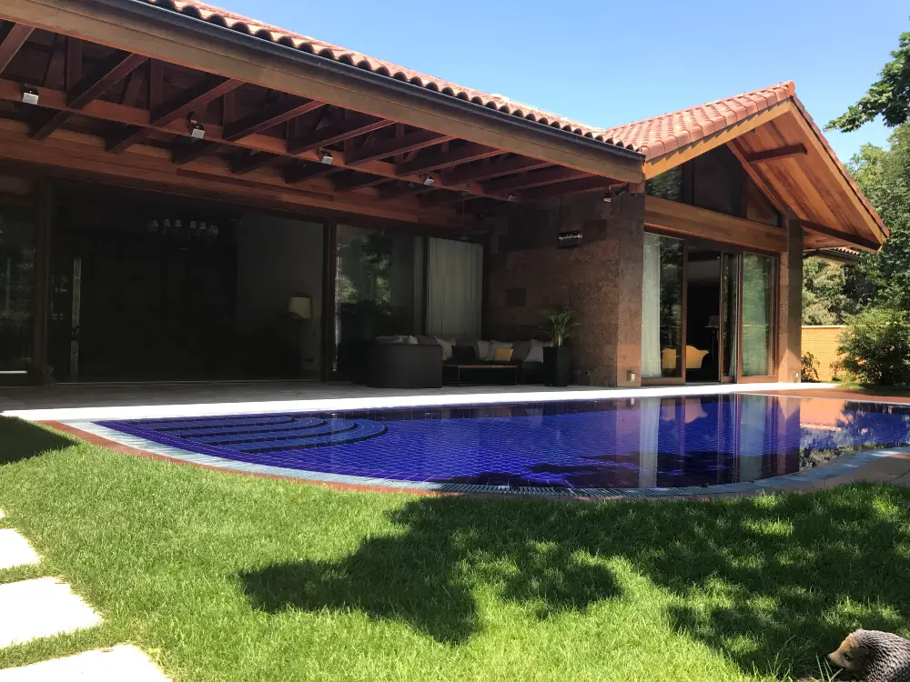 An image of an outdoor covered patio in front of a pool.