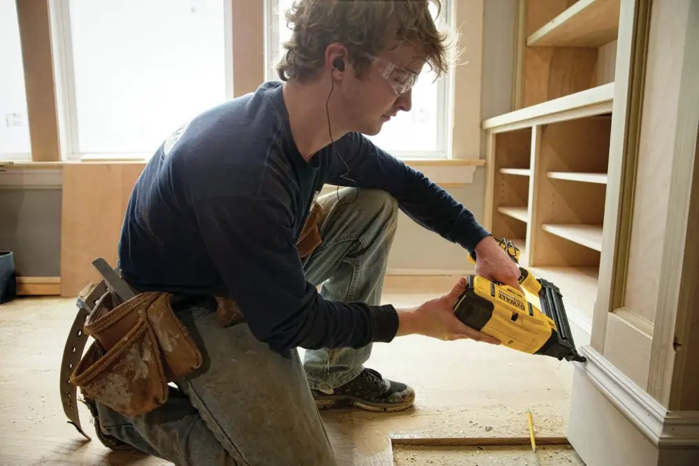 A DIY woodworker using a nailer.