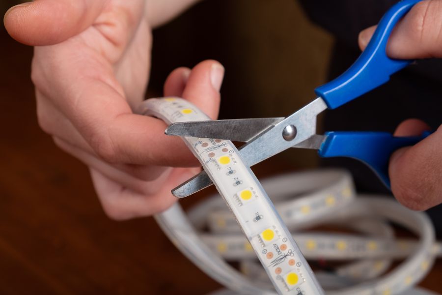 A man trimming LED strip lights.