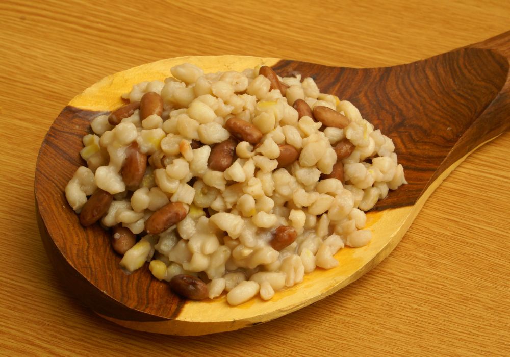 An image of a wooden spoon holding various grains and nuts. 